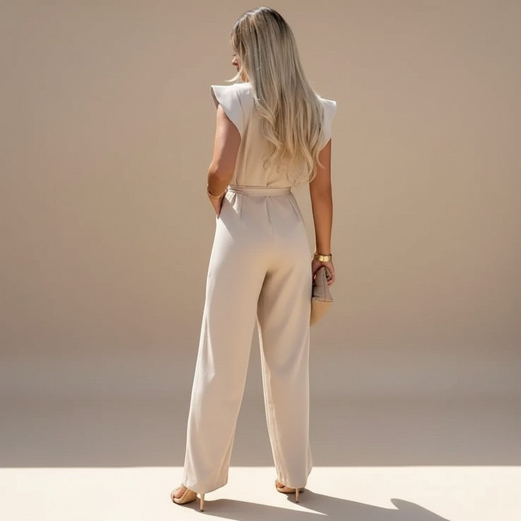 Yemelia beige wide leg jumpsuit with flutter sleeves and adjustable waist tie. Elegant, full-length silhouette.