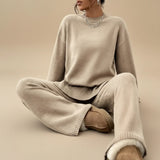 Yemelia beige knit lounge set with crewneck sweater and wide leg pants, featuring ribbed cuffs and hem. Soft and comfortable for casual wear.