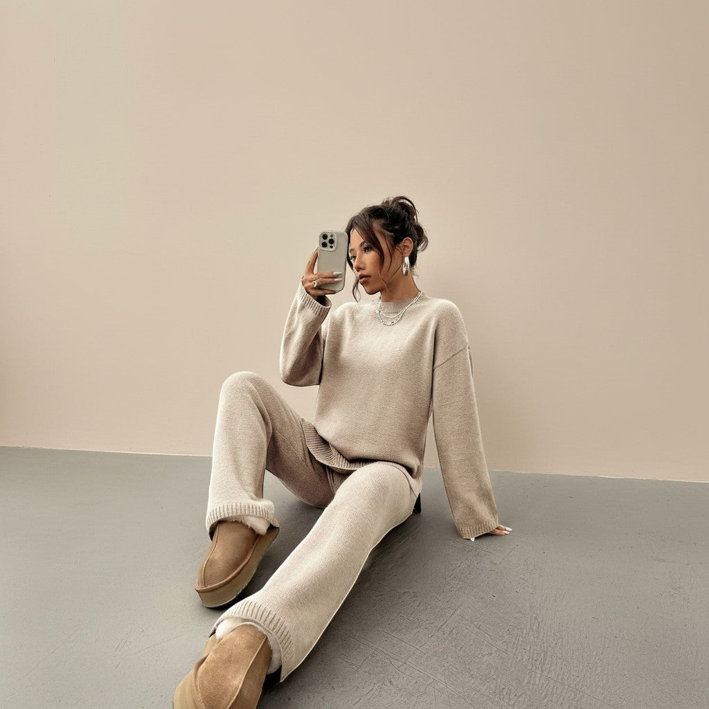 Yemelia beige knit lounge set with relaxed fit sweater and wide leg pants, featuring ribbed cuffs and hem.