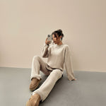 Yemelia beige knit lounge set with relaxed fit sweater and wide leg pants, featuring ribbed cuffs and hem.