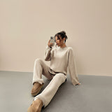 Yemelia beige knit lounge set with relaxed fit sweater and wide leg pants, featuring ribbed cuffs and hem.