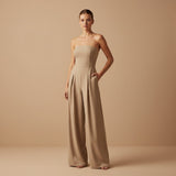 Yemelia beige strapless wide leg jumpsuit with tailored fit and side pockets. Elegant formal wear.