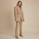 Yemelia beige tailored blazer with relaxed fit, featuring a self-tie belt and classic lapels. Made from smooth, structured fabric.