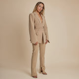 Yemelia beige tailored blazer with relaxed fit, featuring a self-tie belt and classic lapels. Made from smooth, structured fabric.