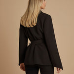 Yemelia black tailored blazer with relaxed fit, self-tie belt, and lapel neckline. Made from smooth, structured fabric.