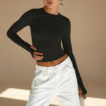 Yemelia black long sleeve fitted top with crew neck and thumbhole cuffs, made from stretch fabric.