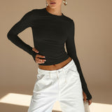 Yemelia black long sleeve fitted top with crew neck and thumbhole cuffs, made from stretch fabric.