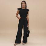 Yemelia black wide leg jumpsuit with flutter sleeves and adjustable waist tie. Elegant, full-length silhouette.