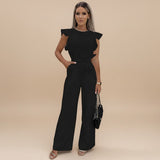 Yemelia black wide leg jumpsuit with flutter sleeves and adjustable waist tie. Elegant, full-length silhouette.