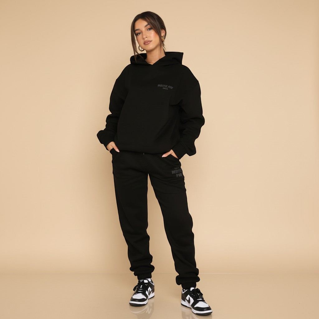 Yemelia black relaxed fit hoodie and jogger set with subtle graphic accent. Soft fabric, elastic waistband, ideal for casual wear.