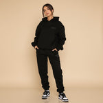 Yemelia black relaxed fit hoodie and jogger set with subtle graphic accent. Soft fabric, elastic waistband, ideal for casual wear.