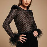 Yemelia black lace jumpsuit with feather cuffs, structured shoulders, and sequin detail. Full length.