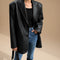 Yemelia black oversized faux leather blazer with tailored structure, classic lapels, and functional pockets.