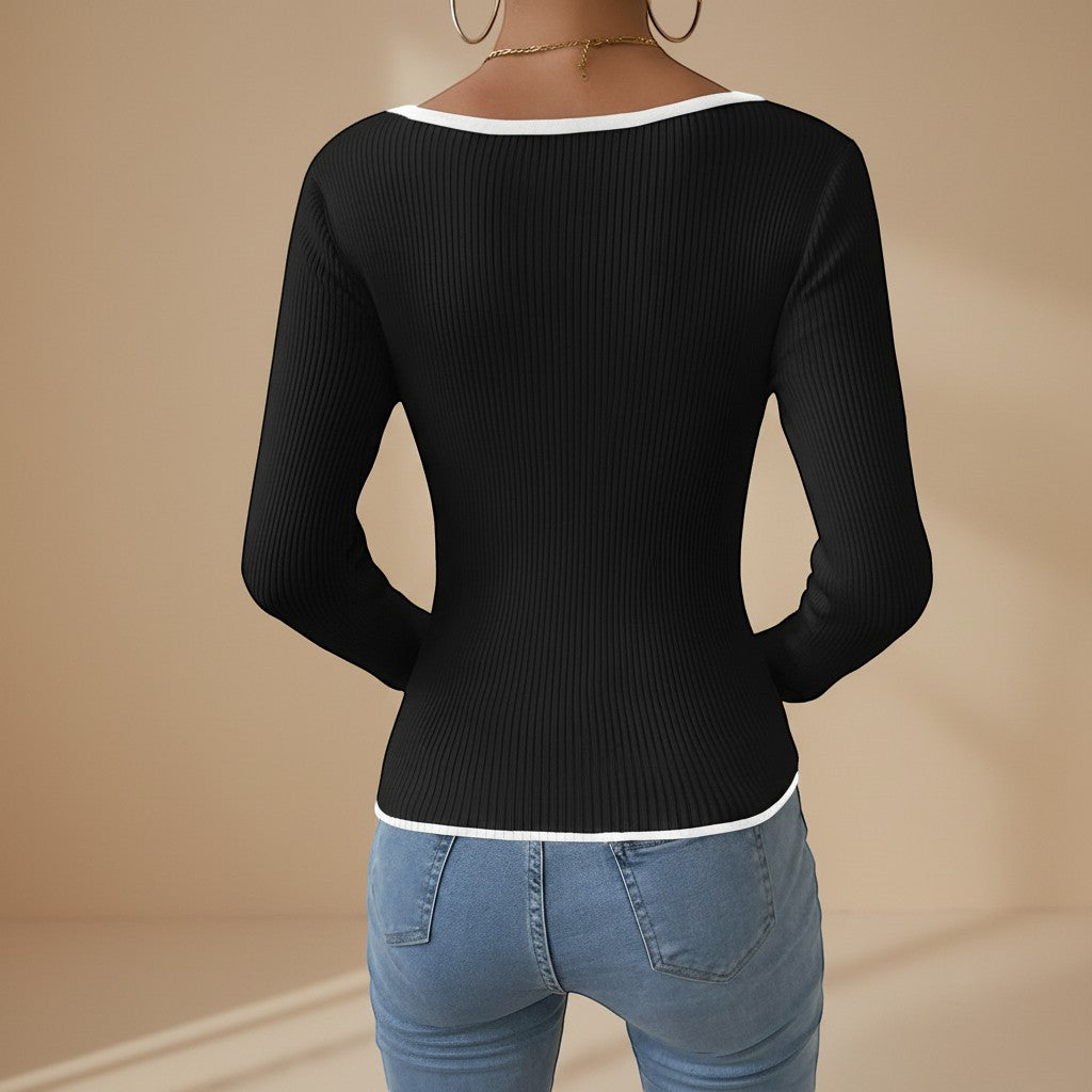 Yemelia black ribbed long sleeve top with contrast trim V-neck and hem. Fitted silhouette.