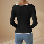 Yemelia black ribbed long sleeve top with contrast trim V-neck and hem. Fitted silhouette.