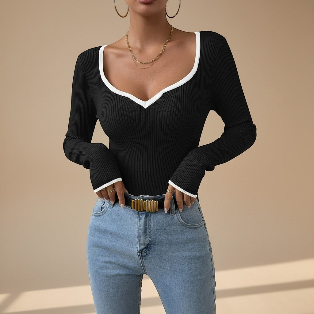Yemelia black ribbed long sleeve top with white contrast trim V-neck and cuffs, fitted silhouette.