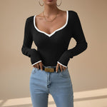 Yemelia black ribbed long sleeve top with white contrast trim V-neck and cuffs, fitted silhouette.