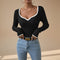 Yemelia black ribbed long sleeve top with white contrast trim V-neck and cuffs, fitted silhouette.