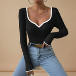 Yemelia black ribbed long sleeve top with contrast trim V neckline and fitted silhouette.