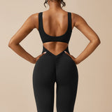 Yemelia black sleeveless sculpting jumpsuit with ruched back and flared legs, made from smooth stretch fabric.