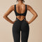 Yemelia black sleeveless sculpting jumpsuit with ruched back and flared legs, made from smooth stretch fabric.