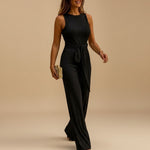 Yemelia black sleeveless sequin wide leg jumpsuit with waist tie, perfect for evening events.