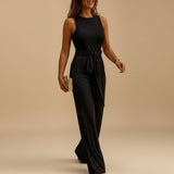 Yemelia black sleeveless sequin wide leg jumpsuit with waist tie, perfect for evening events.
