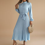 Yemelia light blue long sleeve pleated midi dress with high neck and waist tie. Elegant, flowing silhouette.