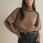 Yemelia brown knit turtleneck sweater with black contrast trim detailing on shoulders and sleeves. Ribbed neckline, cuffs, and hem.