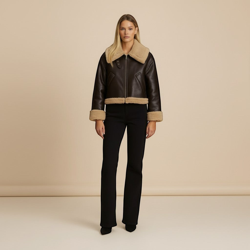 Yemelia brown faux leather jacket with shearling trim on collar, cuffs, and hem. Zip front closure.