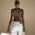 Yemelia long sleeve fitted brown top with thumbhole detail and minimalist neckline, made from stretch fabric.