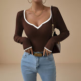 Yemelia brown ribbed long sleeve top with white contrast trim V-neck and cuffs, fitted silhouette.