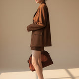 Yemelia brown suede relaxed fit button front blazer with notched lapel and flap pockets.