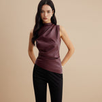 Yemelia sleeveless draped faux leather top in burgundy with a high neckline and asymmetrical hem.