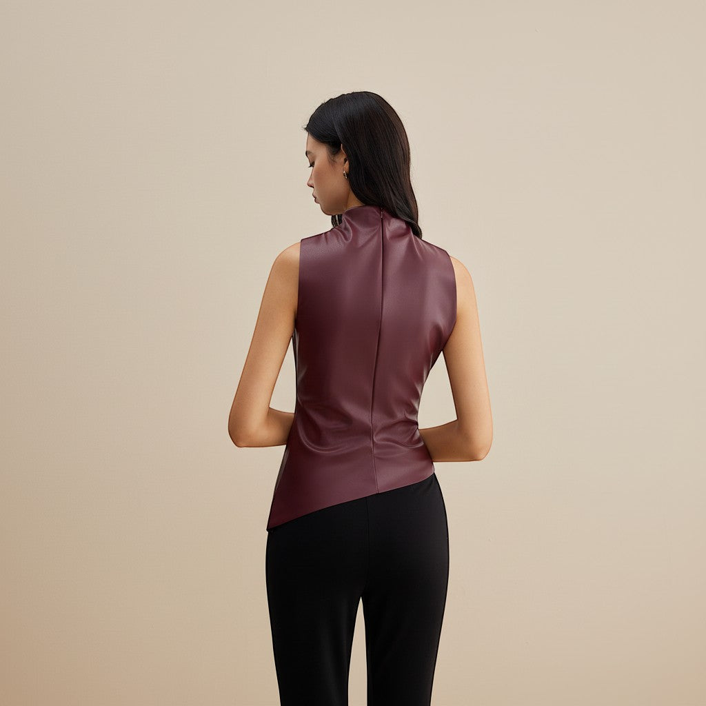 Yemelia sleeveless draped faux leather top in deep burgundy with a high neckline and asymmetric hem.