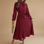 Yemelia burgundy long sleeve pleated midi dress with high neck and waist tie. Elegant, flowing silhouette for events.