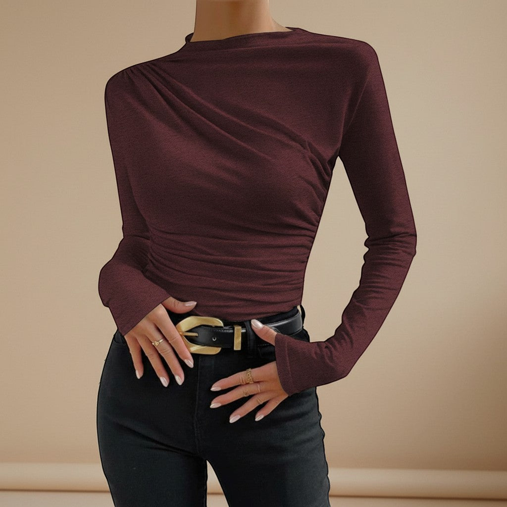 Yemelia burgundy long sleeve fitted top with asymmetrical neckline and ruched detailing, made from stretch fabric.