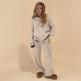 Yemelia light beige knit lounge set with crewneck sweater and wide-leg pants featuring contrast black trim.