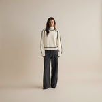 Yemelia cream knit turtleneck sweater with black contrast trim detailing on neckline, shoulders, sleeves, and hem. Relaxed fit.