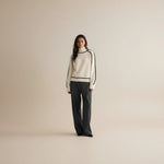 Yemelia cream knit sweater with black contrast trim, ribbed turtleneck, cuffs, and hem. Relaxed fit.