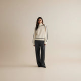 Yemelia cream knit sweater with black contrast trim, ribbed turtleneck, cuffs, and hem. Relaxed fit.