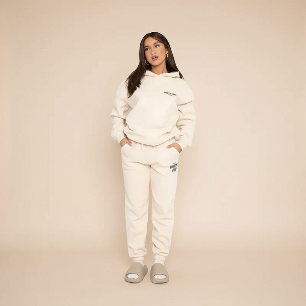 Yemelia cream relaxed fit hoodie and jogger set with graphic accent, made from soft fabric.