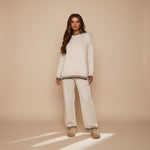 Yemelia cream knit lounge set with crewneck sweater and wide-leg pants featuring black contrast trim.