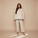 Yemelia cream knit lounge set with crewneck sweater and wide-leg pants featuring black contrast trim.