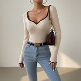 Yemelia cream ribbed long sleeve top with contrast trim V-neck and cuffs. Fitted silhouette.