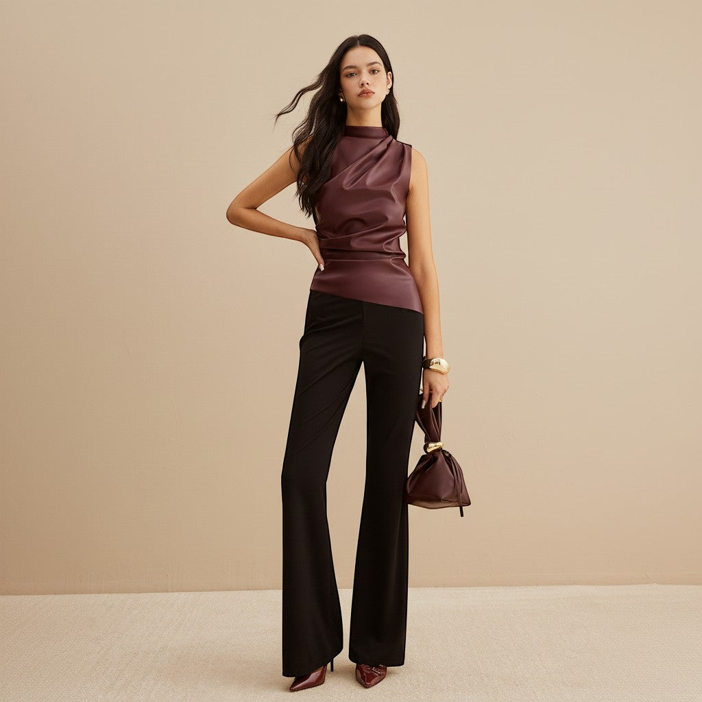 Yemelia sleeveless draped faux leather top in deep burgundy with a high neckline and asymmetric hem. Modern, sophisticated.
