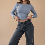 Yemelia dusty blue long sleeve fitted crop top with ruched detail and thumbhole cuffs, made from stretchy fabric.