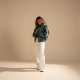 Yemelia dark teal faux leather bomber jacket with zip front, ribbed trim, and contrast stitching. Relaxed fit.