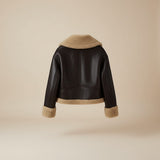 Yemelia dark brown faux leather jacket with tan shearling trim on collar, cuffs, and hem. Zip front.