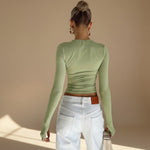 Yemelia light green long sleeve fitted top with thumbhole detail and minimalist neckline, made from stretch fabric.